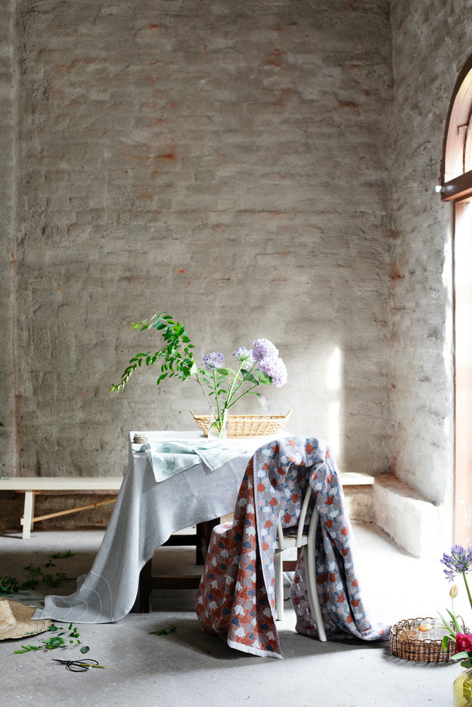 Stort pledd vevd i ull og lin. Stuen eller soverommet. Mønster med tulipaner i kanel, blått og hvitt. Produsert i Finland. 130x240cm