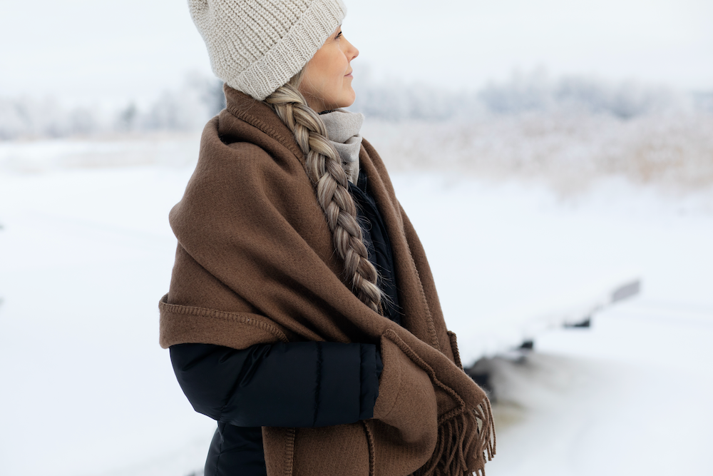Dame med brunt ullsjal på vinteren.